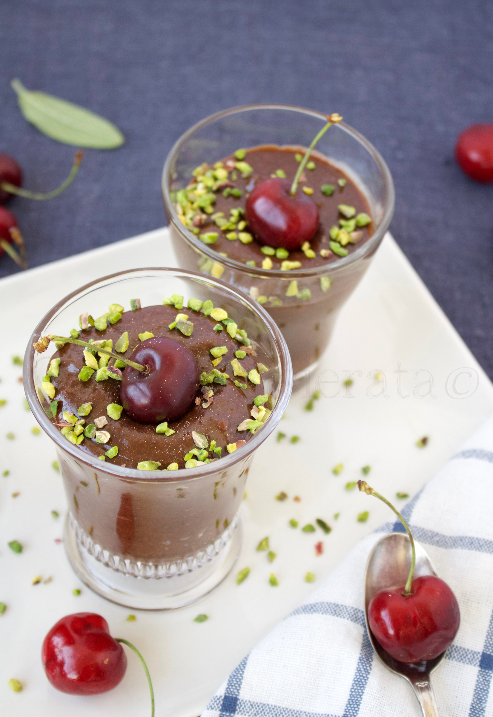 Per 6 persone: Per la crema: 450 ml di latte fresco intero 100 g di zucchero di canna 5 tuorli 50 ml di Moscato di Sorso Sennori Doc 20 g di amido di mais 20 g di farina di grano tenero 00 1 pizzico di sale 1 pizzico di anice stellato in polvere per il croccantino: 75 g di mandorle sgusciate, ma non pelate 65 g di zucchero di canna 7 g di burro Unire latte e moscato, versare in una casseruola, aggiungere 50 g di zucchero. Far scaldare mescolando fino a che lo zucchero sarà completamente sciolto. Nel frattempo montare i tuorli con il rimanente zucchero fino ad avere un composto spumoso. Aggiungere farina, amido di mais e anice stellato setacciando bene. Aggiungere una presa di sale e mescolare (utilizzando ancora le fruste). Versare sul composto uno o due mestolini di latte tiepido. Mescolare accuratamente, quindi trasferire tutto nella casseruola con il rimanente latte. Far addensare la crema a fuoco dolcissimo mescolando senza interruzione con un cucchiaio di legno fino a che non sarà densa e setosa. Versarla, ancora bollente, nelle ciotoline individuali. Lasciarla raffreddare coperta con pellicola per alimenti e poi conservare in frigorifero. Preparare la decorazione di croccantino: in un pentolino dal fondo spesso versare lo zucchero, bagnarlo con un cucchiaio di acqua e farlo sciogliere molto lentamente. Unire le mandorle tritate grossolanamente e cuocere per alcuni minuti. Aggiungere il burro, mescolare, quindi versare il croccante su un foglio di carta forno. Coprire con un secondo foglio e livellare utilizzando un matterello di legno. Eliminare il secondo foglio e lasciar raffreddare. Spezzettarlo. Togliere la crema dal frigorifero con un certo anticipo – meglio non sia troppo fredda – decorare la superficie con il croccantino e servire. Mousse al cioccolato e ciliegie